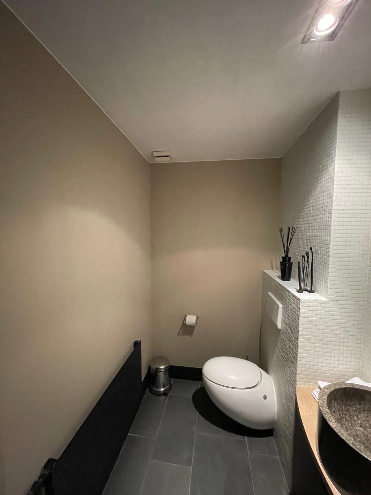 Strak geschilderd toilet met tegelwerk